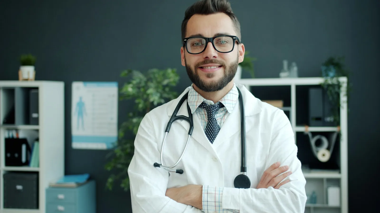 Endocrinologist in a white coat with a stethoscope, smiling with arms crossed in a clinic