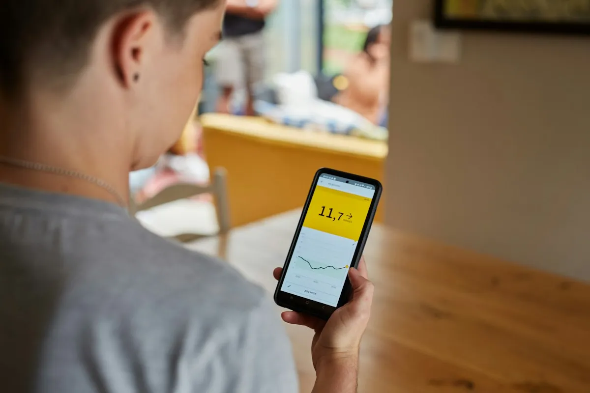 Patient checking continuous glucose monitor readings on a smartphone app